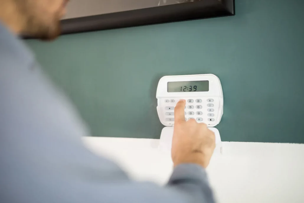 Persona configurando sistema de alarmas en una vivienda.